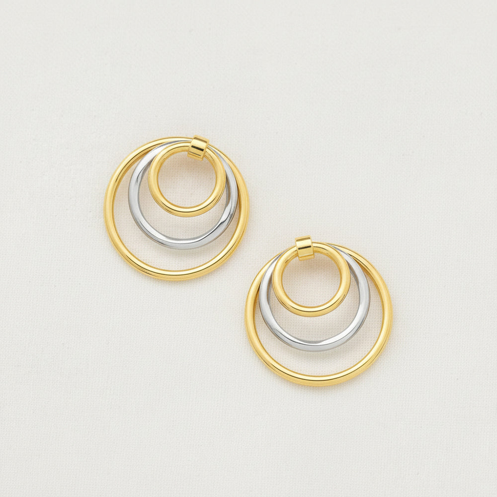 Dual-tone gold and rhodium circular dangler earrings in 925 silver, bold yet elegant — flat lay shot.