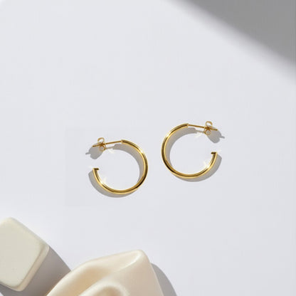 Gold-plated 925 silver hoops from the Enishi collection, minimal yet playful design — flat lay shot.