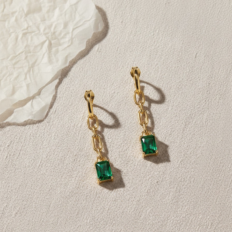 Flat Lay of KiraKira Emerald Danglers | 925 Silver Gold-Plated from Nishani’s Kira Kira festive collection — handcrafted emerald jewelry, earrings in gold-plated 925 silver.