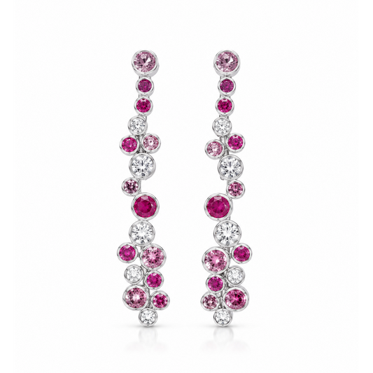 A pair of silver-tone drop earrings adorned with pink and clear round-cut gemstones, arranged in a cascading floral pattern on a solid white background.
