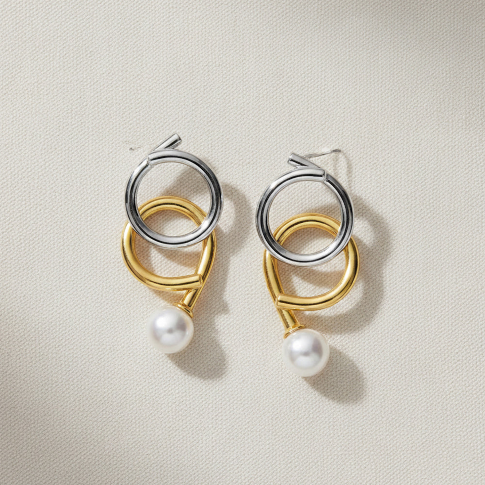 Gold and rhodium knot-a-pearl earrings in 925 silver, bold dual-tone pearl design — flat lay shot.