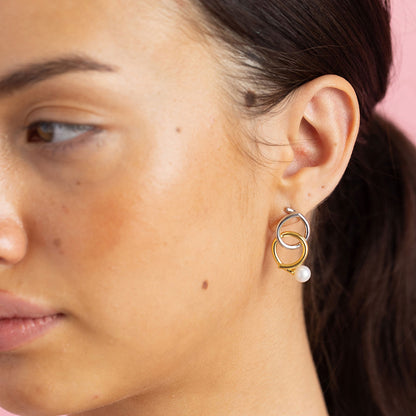 Gold and rhodium knot-a-pearl earrings in 925 silver, bold dual-tone pearl design — model - close-up shot.