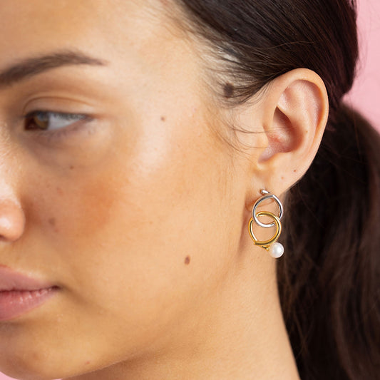 Gold and rhodium knot-a-pearl earrings in 925 silver, bold dual-tone pearl design — model - close-up shot.
