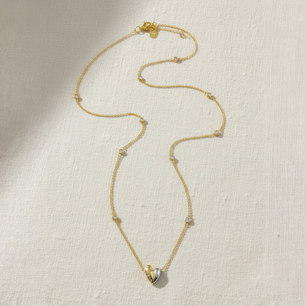 Gold and rhodium organic heart necklace in 925 silver, statement sculptural pendant — flat lay shot.