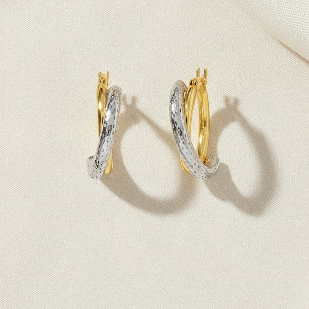 Gold and rhodium overlap hoops in 925 silver, dynamic dual-tone design — flat lay shot.