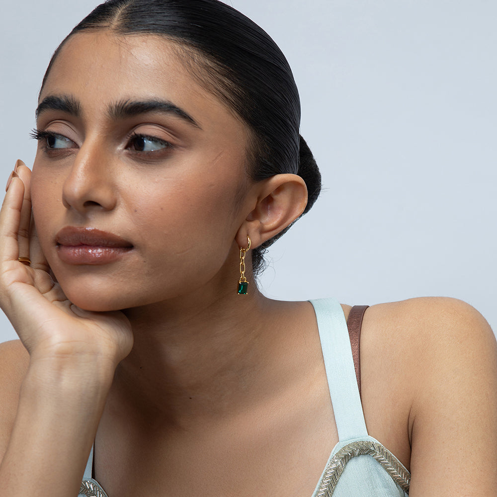 Model Image 1 of KiraKira Emerald Danglers | 925 Silver Gold-Plated from Nishani’s Kira Kira festive collection — handcrafted emerald jewelry, earrings in gold-plated 925 silver.