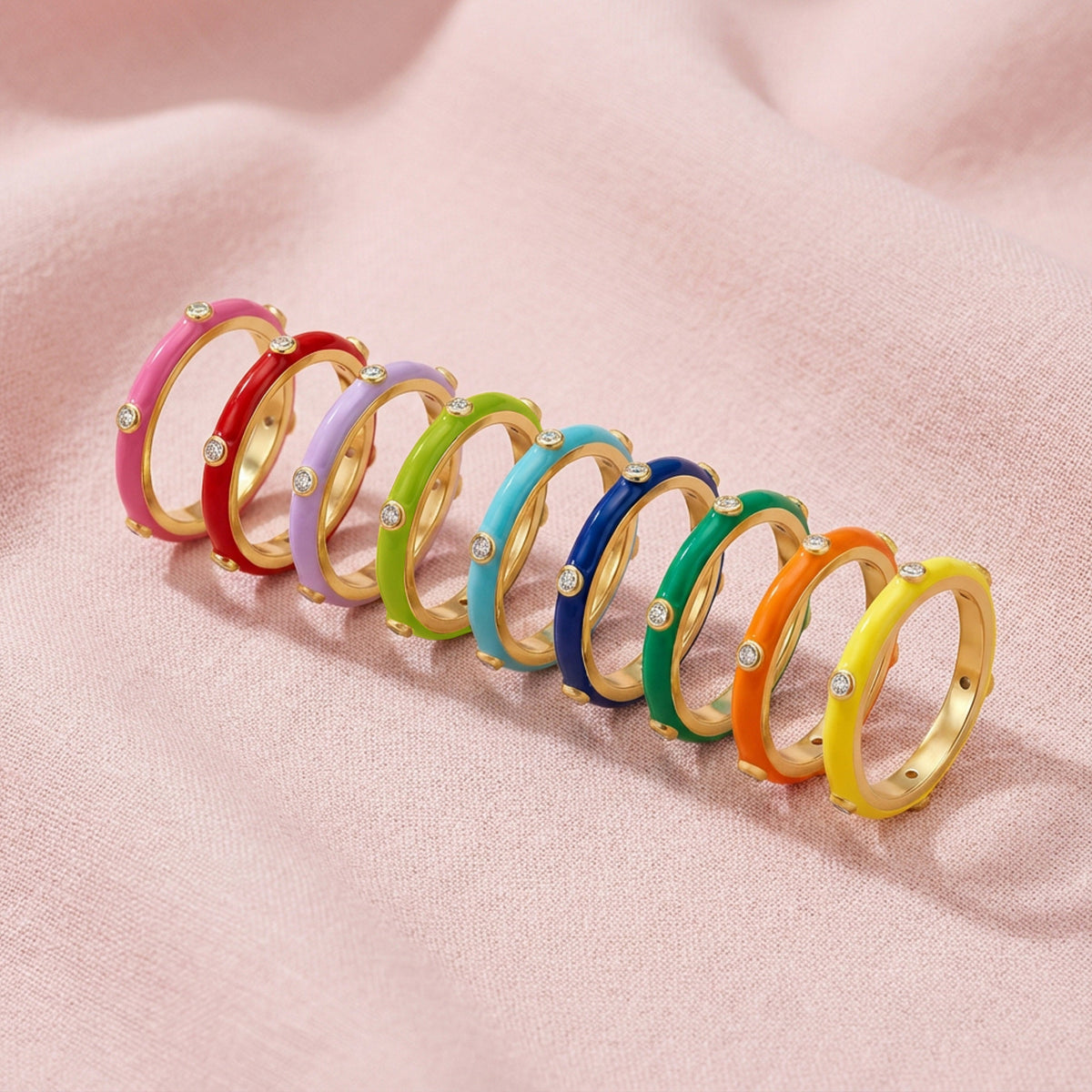 Row of colorful rings on a pink fabric background
