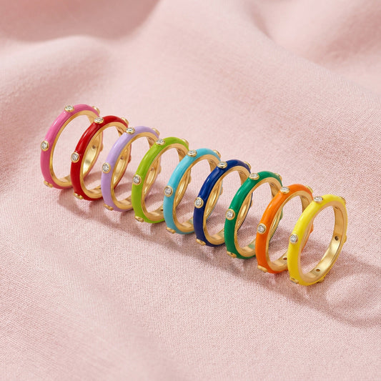 Row of colorful rings on a pink fabric background