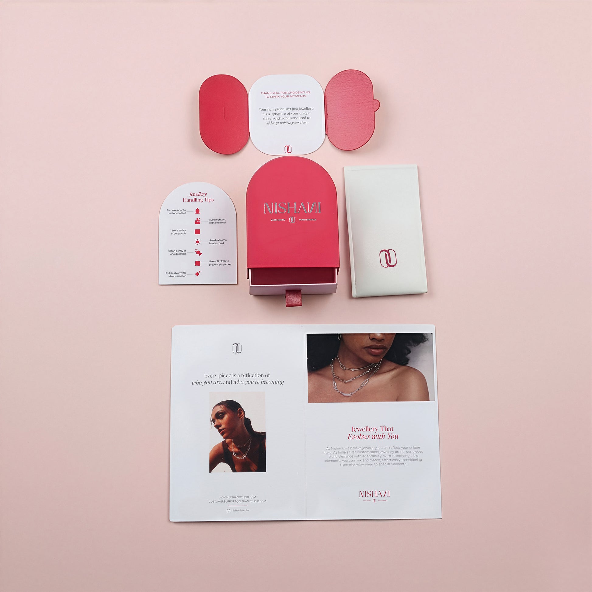 Nishani jewelry packaging with brochures on a pink background