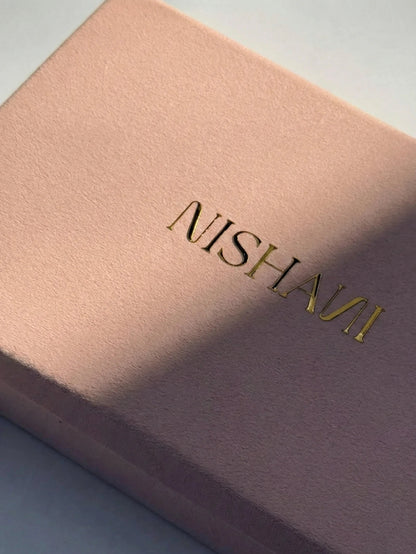 Pink velvet with 'Nishani' embossed on it against a light blue background