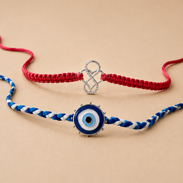 Two braided cord bracelets on a warm beige background. The top bracelet is made of red cord with a silver infinity charm.