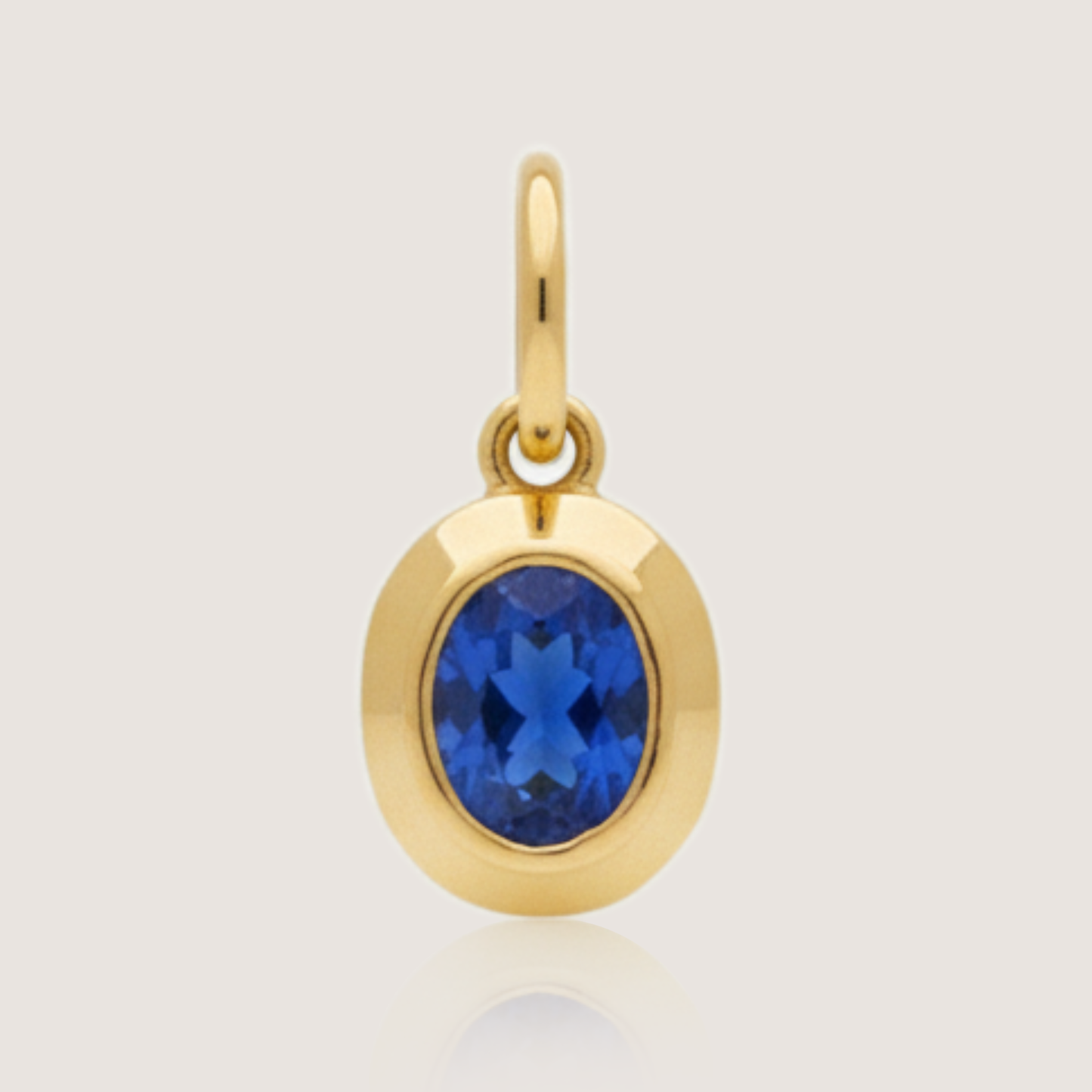 White Background - Front of KiraKira Oval Sapphire Charm | 925 Silver Gold-Plated from Nishani’s Kira Kira festive collection — handcrafted sapphire jewelry, charm in gold-plated 925 silver.