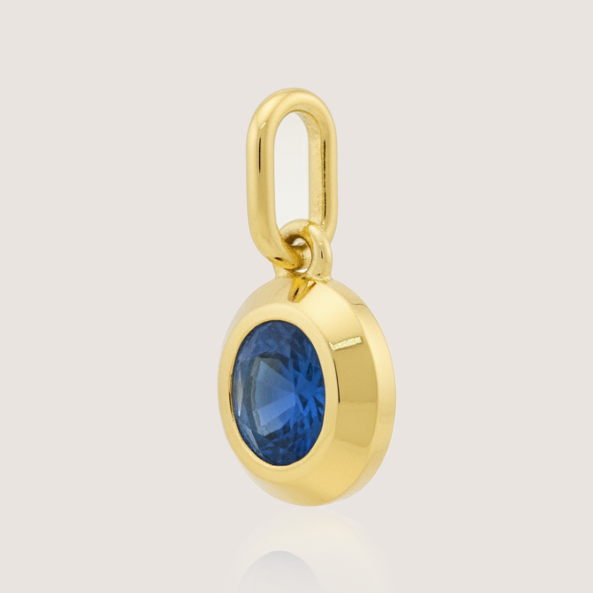 White Background - Side of KiraKira Oval Sapphire Charm | 925 Silver Gold-Plated from Nishani’s Kira Kira festive collection — handcrafted sapphire jewelry, charm in gold-plated 925 silver.