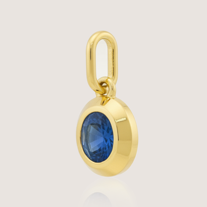 White Background - Side of KiraKira Oval Sapphire Charm | 925 Silver Gold-Plated from Nishani’s Kira Kira festive collection — handcrafted sapphire jewelry, charm in gold-plated 925 silver.